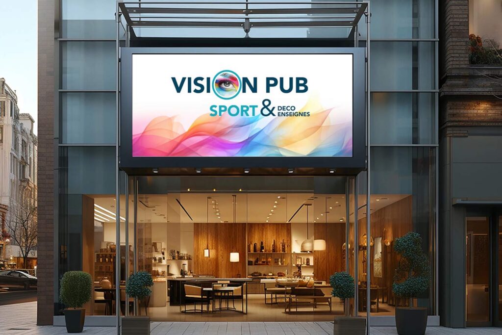 Écran numérique lumineux affichant 'VISION PUB SPORT & DECO ENSEIGNES' au-dessus d'une vitrine de magasin moderne.