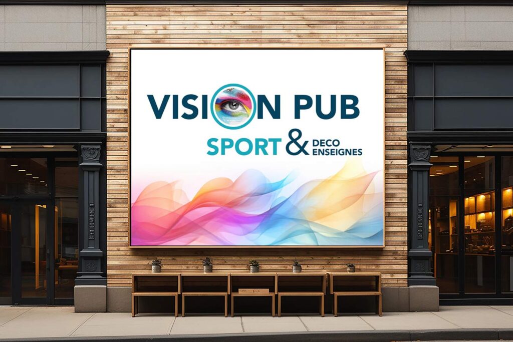 Grand panneau lumineux sur façade en bois clair affichant 'VISION PUB SPORT & DECO ENSEIGNES' avec un œil coloré et des vagues abstraites.