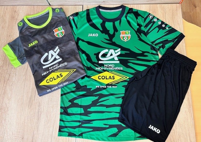 Maillots de football Jako Foot Montaigne et tenues Colas Deux maillots de football Jako (gris et vert) et un short noir, avec les logos Crédit Agricole, Colas "We Open The Way" et le blason Foot Montaigne.